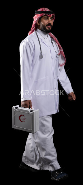 المشي والذهاب إلى المراكز الطبية، المعدات الطبية اللازمة، بورتريه لطبيب عربي خليجي سعودي يرتدي الثوب التقليدي و المعطف الطبي يمسك بيده حقيبة الاسعافات الاولية، تقديم الرعاية الصحية للمرضى، العمل في المستشفيات الخاصة ، صورة الجسم بالطول الكامل، خلفية سوداء
