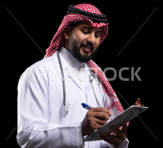 الاستماع إلى حالة المريض بإيماءات السرور والبشاشة، تقديم الاستشارات الطبية والخدمات الصحية، بورتريه مقرب لطبيب عربي خليجي سعودي يرتدي الزي التقليدي والمعطف الطبي يقوم بإعداد التقارير الطبية، مهن ووظائف سعودية، العمل في القطاع الصحي، خلفية سوداء