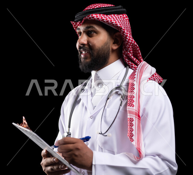 حسن التعامل مع المراجعين، تدوين المعلومات العامة عن حالة المريض، بورتريه مقرب لطبيب عربي خليجي سعودي يرتدي الثوب التقليدي و المعطف الطبي ويحمل بيده ملفات المرضى، اعداد التقارير الطبية ، العمل في القطاع الصحي، خلفية سوداء