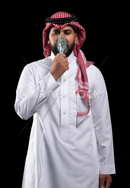 Treating chronic asthma diseases, maintaining a regular airway using a respirator, portrait of a Saudi Gulf Arab man wearing a shemagh and traditional dress, inhaling medications to treat apnea, providing home health services to the patient, black background