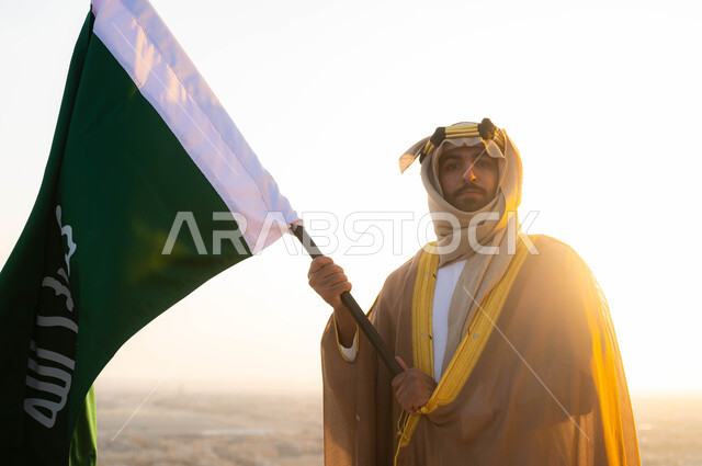 إحياء ذكرى توحيد البلاد في 1727 م، الحفاظ على الهوية الوطنية والفخر بتراثها ،ذكرى يوم التأسيس في 22 شباط، الزي الشعبي التقليدي في المنطقة الوسطى ، مؤسس الدولة السعودية الاولى الامام محمد بن سعود, سيد عربي خليجي سعودي يرتدي البشت والغترة يحمل بيده علم التأسيس 