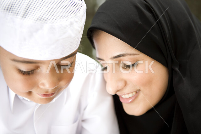 النظر الى بعضهم البعض بكل حب , رحله عائليه في يوم مشمس, صورة مقربة لطفل عربي إماراتي خليجي يلعب مع والدته في المنتزه, مفهوم الأسره السعيدة، قضاء أوقات عائلية ممتعة, عطلة نهاية الاسبوع, اللعب مع الابناء