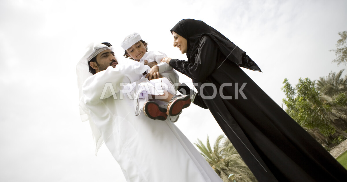 أم واب يحملون ابنهم في احدى الحدائق العامة, ايماءات الحب والعطف على ...