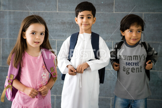 الاستعداد للعام الدراسي الجديد, تلاميذ عرب خليجيون إماراتيون يرتدون حقيبة الظهر المدرسية, النظر إلى الكاميرا بإيماءات السعادة بالعودة إلى المدرسة, المدارس الأكاديمية في الإمارات العربية المتحدة