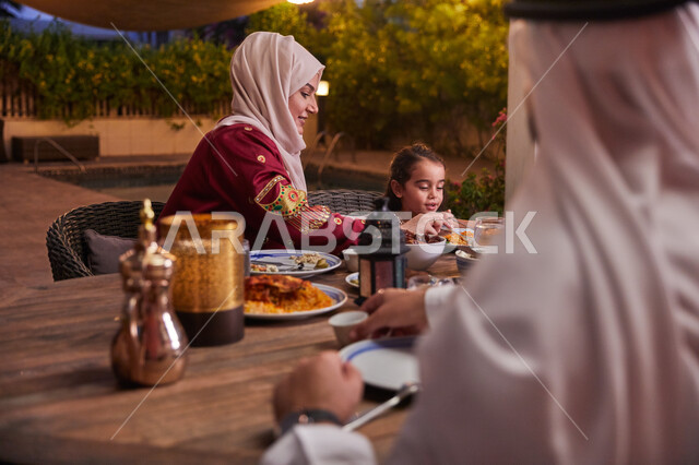 طاوله إفطار مليئه بالأصناف والمأكولات الشهية، كسر الصيام عند سماع أذان المغرب، قضاء أوقات ممتعه مع العائله في الخارج، أسرة عربيه خليجيه اماراتية تقوم بتناول الطعام العائلي في أحد المطاعم، ديكورات وأجواء رمضانيه.