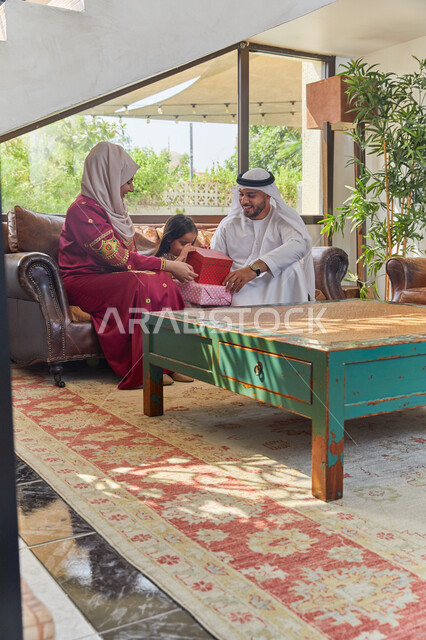 ادخال الفرحة والسرور إلى قلب البنات، حسن المعاملة وتربيه الأبناء في الإسلام، تقديم الهدايا والمفاجآت للأطفال، زوجان عربيان خليجيان اماراتيان يقومان بإعطاء هدية لإبنتهم بمناسبة عيد ميلادها، المكافآت والجوائز في الأعياد والمناسبات.
