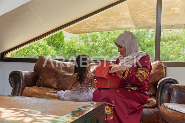 إنشاء الأطفال على الحب والعطاء والتربية الصالحة، قضاء الأوقات الممتعه مع الأبناء، فتاة عربيه خليجيه اماراتية تحتفل بعيد الأم وتقدم لوالدتها الهدية، ايماءات تدل على الفرح والسعلاده، الإحتفال سويا في الأعياد والمناسبات.