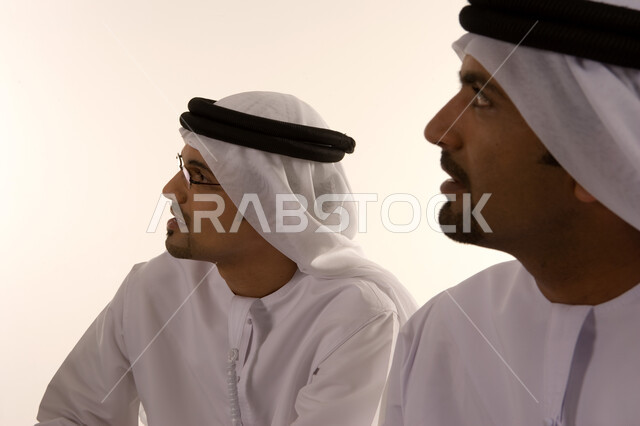 المساهمة في تطوير المهارات والخبرات, التمتع بصفة الرياده والاصرار على النجاح, ارتداء الزي الإماراتي التقليدي، مهن ووظائف إماراتية، شركات ومكاتب خليجية في الإمارات العربية المتحدة، صورة مقربة لزميلا عمل عربيان إماراتيان خليجيان يجلسان في مقر الشركة