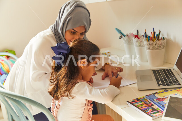 ادخال التقنية والتكنولوجيا بالتعليم، متابعة منصات التعليم الالكتروني المتاحة عبر الانترنت بإستخدام اجهزة الحاسب و التابلت، حل الواجبات المنزليه، معلمة خصوصي لمتابعة الدروس في المنزل، أم عربية خليجة اماراتية محجبة تقوم بتعليم وتدريس ابنتها