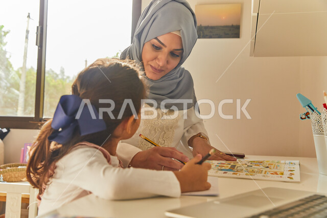 استاذة خصوصي لمتابعة الدروس في المنزل، دمج التعليم مع التقنية والتكنولوجيا، حل الواجبات المنزليه، أم عربية خليجة اماراتية محجبة تقوم بتعليم وتدريس ابنتها، تنمية المهارات الثقافية والقدرات الفكرية للابناء