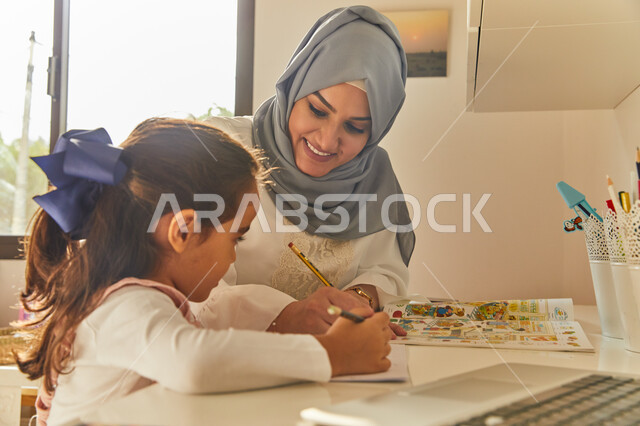 معلمة خصوصي لمتابعة الدروس في المنزل، دمج التعليم مع التقنية والتكنولوجيا، حل الواجبات المنزليه، أم عربية خليجة اماراتية محجبة تقوم بتعليم وتدريس ابنتها، تنمية المهارات الثقافية والقدرات الفكرية للابناء