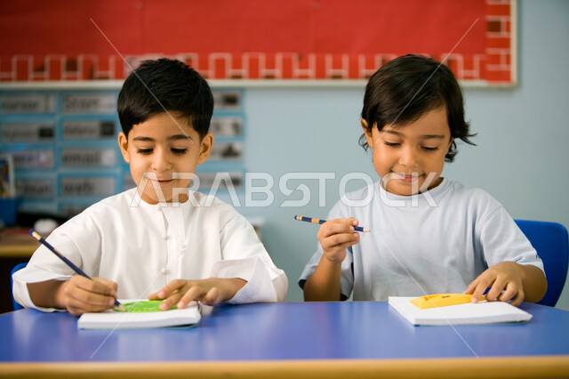 استخدام الأدوات الهندسية وتنمية مهارة الابتكار، صورة مقربة لتلميذين عربيين خليجين اماراتيين يرتديان الزي الكاجوال الاماراتي, تعلم الأشكال الهندسية وطريقة رسمها, تطور وسائل التعليم في الإمارات، الاستمتاع بالنشاطات الجماعية لطلاب التمهيدي