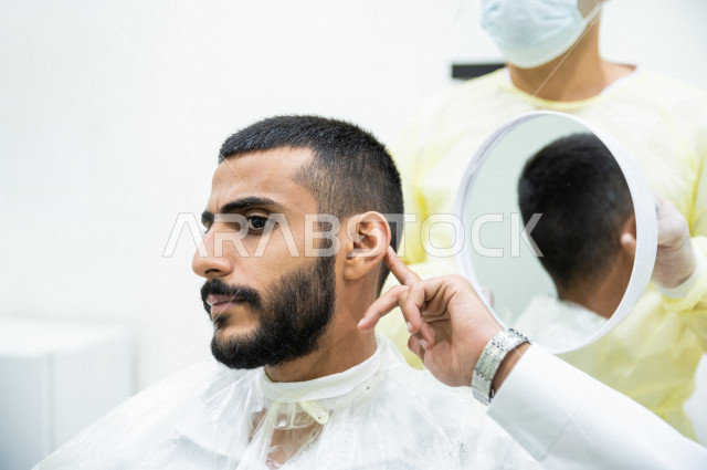 شاب سعودي خليجي في صالون الحلاقة ، ايماءات وجه مختلفة ، الحصول على مظهر انيق و رائع ، الاهتمام و العناية بالمظهر الخارجي