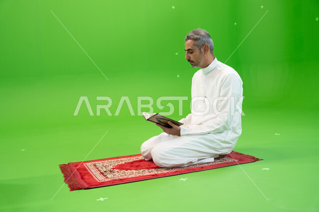 حفظ وتلاوة القرآن الكريم، التسبيح وذكر الله تعالى، كروما لرجل عربي خليجي سعودي يرتدي الثوب التقليدي يحمل بيده المصحف الشريف ويجلس على سجادة الصلاة، العبادة والتقرب إلى الله، أدعية وأذكار إسلامية، إسلاميات وعبادة، خلفية خضراء