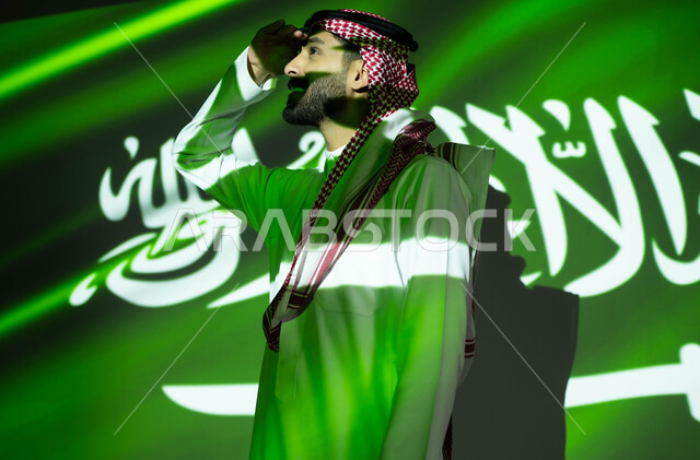 إيماءات التدقيق والمعاينة عن بعد، اندماج ضوء العلم مع الجسم، الاحتفال بيوم العلم 11مارس والعيد الوطني، احتفالات ومناسبات وطنية ، رجل عربي خليجي سعودي يرتدي الزي التقليدي يضع يديه فوق عينيه وينظر إلى شيء ما, ذكرى اليوم الوطني السعودي 23 سبتمبر