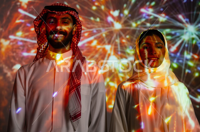 مشاركة العائلة بالذكريات السنوية، الاستمتاع بالمفرقعات والألعاب النارية في الأعياد والمناسبات الوطنية، صورة مقربة لزوجين عربيين خليجيين سعوديين يحتفلان بالأفراح السعيدة، مفهوم حب الوطن والانتماء إليه، فعاليات وانشطة ترفيهية في العيد الإسلامي المبارك.