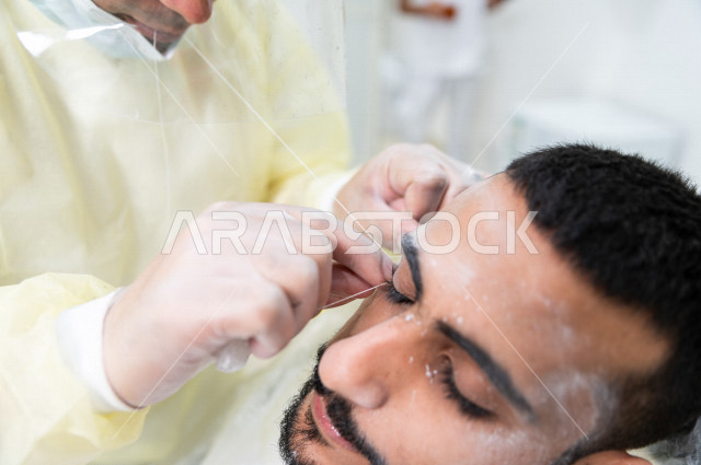 رجل سعودي خليجي في زيارة لصالون الحلاقة ، ازالة شعرالوجه باستخدام تقنية الخيط ، العناية بالمظهر الخارجي 