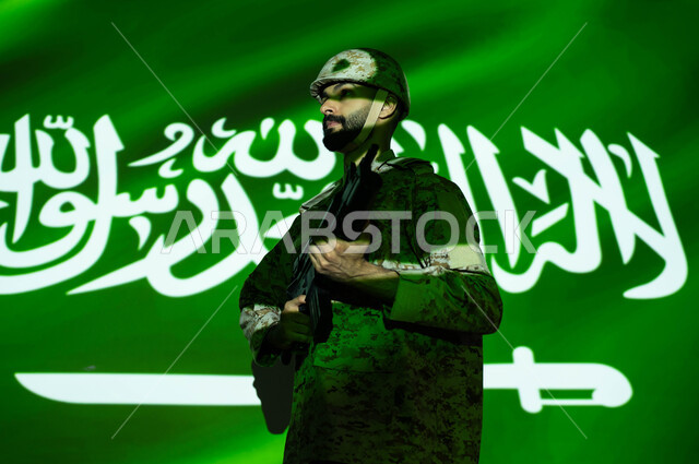 Immersing the body in the light of science, strengthening military forces to increase security and stability in Saudi Arabia, commemorating Saudi National Day September 23, celebrating National Day, Flag Day March 11, side image of a Gulf Arab soldier wearing military uniform and helmet holding a weapon.