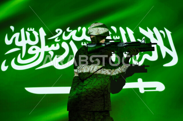 الاحتفال بذكرى اليوم الوطني 23 سبتمبر والعيد الوطني، انعكاس ضوء علم المملكة على جسد الشاب، يوم العلم 11 مارس، جندي عربي خليجي سعودي يرتدي الزي العسكري والخوذة يحمل السلاح، حفظ الأمن والاستقرار بقوات الجيش السعودي، حب الوطن والدفاع عنه