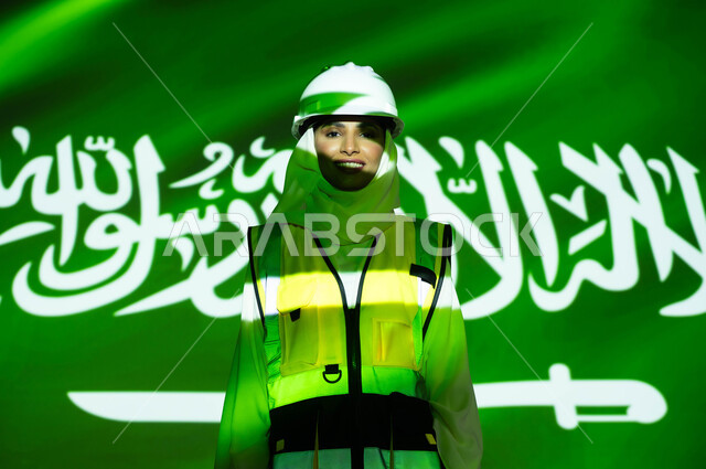 ازدهار القطاع الهندسي بسواعد أبناء الوطن, صورة مقربة لمهندسة عربية خليجية سعودية مبتسمة محجبة ترتدي السترة وخوذة الحماية، اندماج الجسم بضوء العلم، يوم العلم 11 مارس، الإحتفال بذكرى اليوم الوطني السعودي 23 و العيد الوطني ، وظائف نسائية