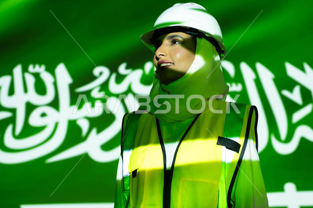 Supporting and developing the engineering sector with the help of the people of the country, a close-up picture of a smiling, veiled Saudi Arabian Gulf engineer wearing a jacket and a protection helmet, the merging of the body with the light of science, Saudi Flag Day, March 11, celebrating the anniversary of the Saudi National Day, September 23, and the National Day, women’s professions and jobs