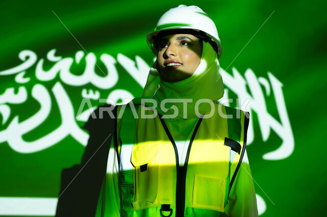 Supporting and developing the engineering sector with the help of the people of the country, a close-up picture of a smiling, veiled Saudi Arabian Gulf engineer wearing a jacket and a protection helmet, the merging of the body with the light of science, Saudi Flag Day, March 11, celebrating the anniversary of the Saudi National Day, September 23, and the National Day, women’s professions and jobs