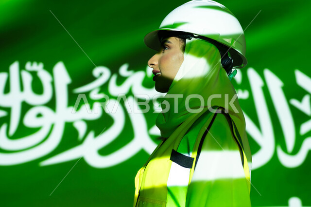 مهن ووظائف نسائية، ازدهار القطاع الهندسي بسواعد أبناء الوطن, صورة مقربة من الجانب لمهندسة عربية خليجية سعودية محجبة ترتدي السترة وخوذة الحماية، اندماج الجسم بضوء العلم، يوم العلم السعودي 11 مارس، الإحتفال بذكرى اليوم الوطني السعودي 23 سبتمبر و العيد الوطني .