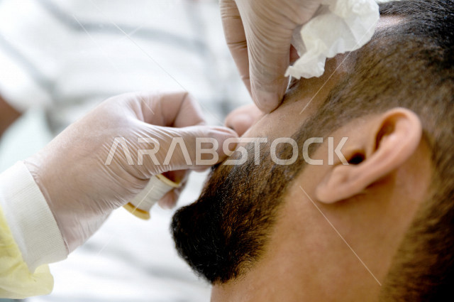 رجل سعودي خليجي في زيارة لصالون الحلاقة ، ازالة شعرالوجه باستخدام تقنية الخيط ، العناية بالمظهر الخارجي 