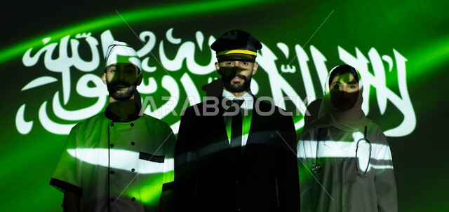 تحقيق التطور والنمو بسواعد أبناء الوطن، احياء ذكرى اليوم الوطني السعودي 23 سبتمبر ،صورة مقربة لانعكاس ضوء العلم على موظفون عرب خليجيون سعوديون يرتدون زي العمل المخصص ، الاحتفال بيوم العلم السعودي 11 مارس والعيد الوطني، تنيمة وازدهار البلاد بثقافة أجيالها