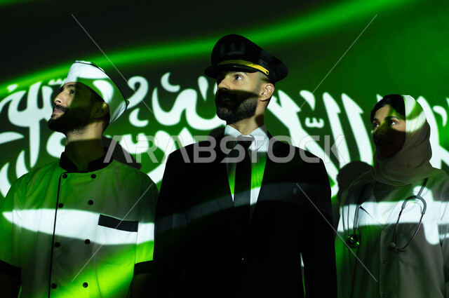 Joining together of various professions to advance and advance the nation, prosperity and development of the country through youth culture, celebrating the Saudi Flag Day, March 11, and National Day, commemorating the Saudi National Day, September 23, a close-up of the reflection of the flag’s light on Saudi Gulf Arab employees wearing custom work uniforms.