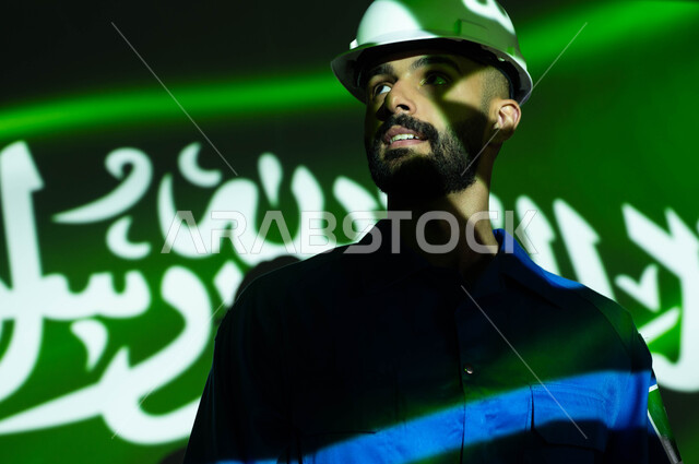 تطور ونمو ودعم قطاع الفضاء في السعودية، صورة مقربة لرائد فضاء عربي خليجي سعودي يرتدي بدلة الفضاء الزرقاء بشعار علم السعودية وخوذة الحماية، انعكاس ضوء العلم على الوجه، الاحتفال  بيوم العلم 11 مارس والعيد الوطني، ذكرى اليوم الوطني السعودي في 8 ربيع الأول.