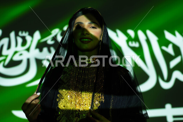 Love and loyalty to the Kingdom, Flag Day, March 11, celebration of the Saudi National Day, September 23, a close-up of a smiling Saudi Gulf Arab woman wearing the sheila and the central region’s dress on National Day, national celebrations and events, immersing the body in the light of science, Founding Day 1727 AD