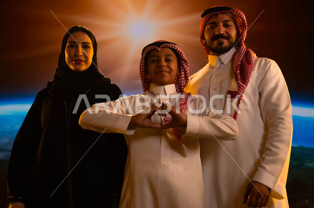نمو وتطور قطاع الفضاء في المملكة، أجواء عائلية سعيدة مليئة بالحب، عائلة عربية خليجية سعودية تقف بثقة وتنظر إلى الكاميرا، إيماءات السرور والسعادة، طفل يقوم بحركة يد تدل على الحب، رحلة السعودية إلى الفضاء الخارجي، خلفية شروق الشمس على الكرة الأرضية