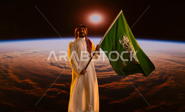 تطور ونمو القطاع الفضائي، رجل عربي خليجي سعودي يرتدي الزي التقليدي ينظر إلى الكاميرا ويحمل علم السعودية، مفهوم الإنتماء وحب البلاد، الإحتفال باليوم الوطني السعودي، يوم العلم 11 مارس، ذكرى العيد الوطني 23 سبتمبر، خلفية شروق الشمس على الأرض