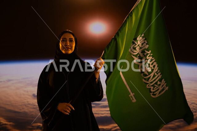 ذكرى اليوم الوطني لتوحيد المملكة، امرأة عربية خليجية سعودية مبتسمة ترتدي العباءة والحجاب وتحمل علم السعودية، التعبير عن الحب والولاء للوطن، يوم العلم السعودي 11 مارس، العيد الوطني 23 سبتمبر، رحلة السعودية للفضاء الخارجي، خلفية الكرة الأرضية