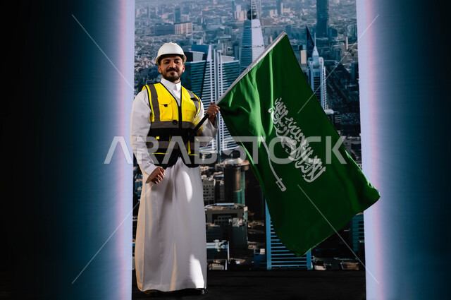 الاحتفال بيوم العلم 11 مارس, تخليد تاريخ اليوم الوطني لتوحيد السعودية 8 ربيع الاول, العيد الوطني السعودي, مهندس عربي سعودي خليجي مبتسم يرتدي الخوذة وسترة الحماية ويمسك علم المملكة, نهضة الوطن بفضل أبنائه, خلفية أبراج الرياض المتميزة