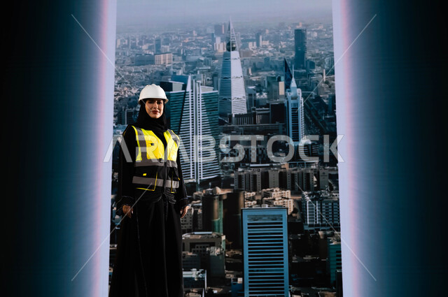 بناء الوطن بسواعد أبنائه ومهندسيه, إيماءات الافتخار و الاعتزاز بالنهضة العمرانية للمملكة, مشاريع إعمارية سعودية وطنية, مهندسة عربية سعودية خليجية محجبة ترتدي الخوذة وسترة الحماية تقف بشموخ, التطور العمراني المتميز للرياض, خلفية أبراج الرياض