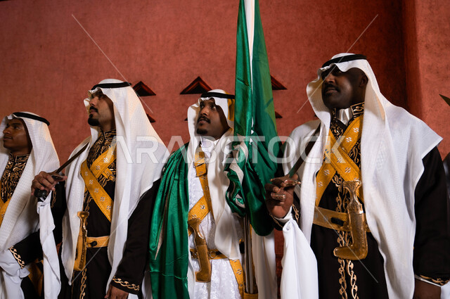 Traditional folklore on national occasions, commemorating the Saudi National Day on September 23, a close-up photo of the Hejazi Ardha band and folk dancing with swords in front of the National Historical Museum in Riyadh, wearing the Dakla costume and the popular bralette, celebrating Saudi Flag Day on March 11