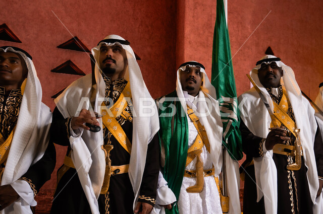 Traditional folklore on national occasions, commemorating the Saudi National Day on September 23, a close-up of the Hijazi Ardha band and folk dancing with swords in front of the National Historical Museum in Riyadh, wearing the traditional Dakla costume and the traditional bralette, celebrating Saudi Flag Day on March 11.