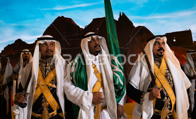 فنون وعروض الفلكلور التراثي السعودي، ذكرى اليوم والعيد  الوطني 23 سبتمبر، أزياء الاحتفالات والمناسبات الوطنية التقليدية، ارتداء الدقلة والفرميلة الشعبية، يوم العلم السعودي 11 مارس، صورة مقربة لفرقة العرضة الحجازية والنظر إلى شيء ما، مفهوم حب الوطن