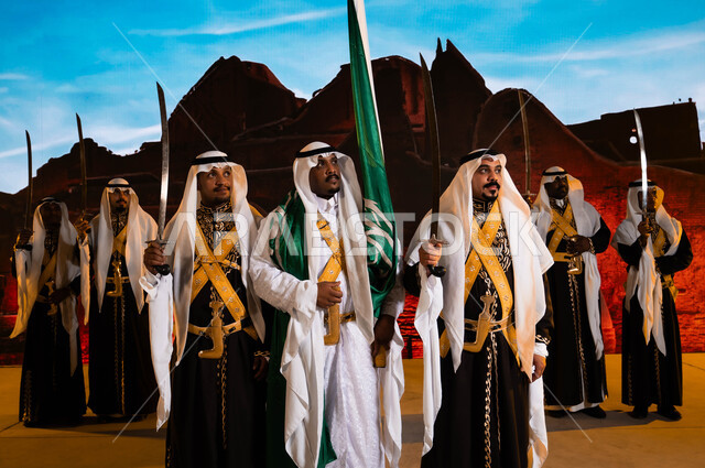 فنون وعروض الفلكلور التراثي السعودي، ذكرى اليوم الوطني 23 سبتمبر، أزياء الاحتفالات والمناسبات الوطنية التقليدية، ارتداء الدقلة والفرميلة الشعبية، الاحتفال بيوم العلم السعودي 11 مارس، صورة مقربة لفرقة العرضة الحجازية والنظر إلى شيء ما، مفهوم حب الوطن