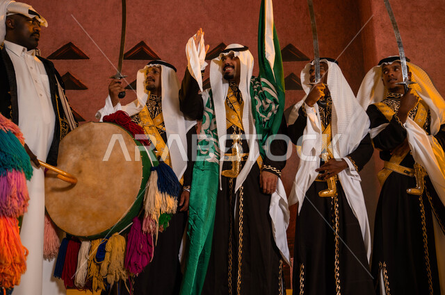 Traditional folklore performances, folk dances and songs on national occasions, the Hijazi Ardha band in front of the National Historical Museum in Riyadh, wearing the traditional Dakla costume and the folk dress, commemorating the Saudi National Day on Rabi’ al-Awwal 8, celebrating the Saudi Flag Day on March 11.