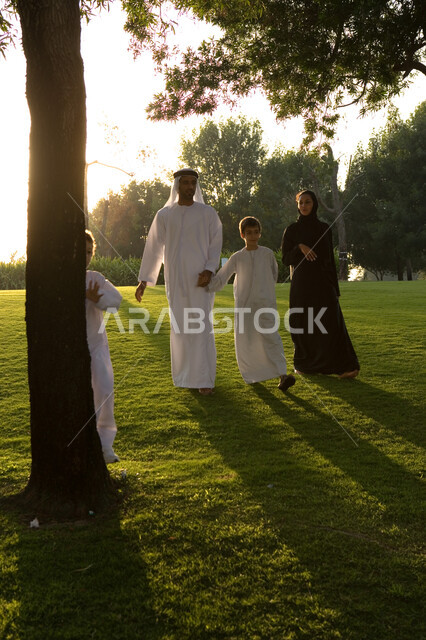 فعاليات وأنشطة ترفيهية مسلية للأطفال في الإجازة, قضاء أوقات ممتعة مع العائلة في عطلة صيفية, عائلة عربية خليجية إماراتية تقوم بالتجول و المشي في الطبيعة الخضراء في إحدى حدائق الإمارات, حدائق ومنتزهات عائلية خضراء, مفهوم الأسرة الاماراتية المترابطة السعيدة