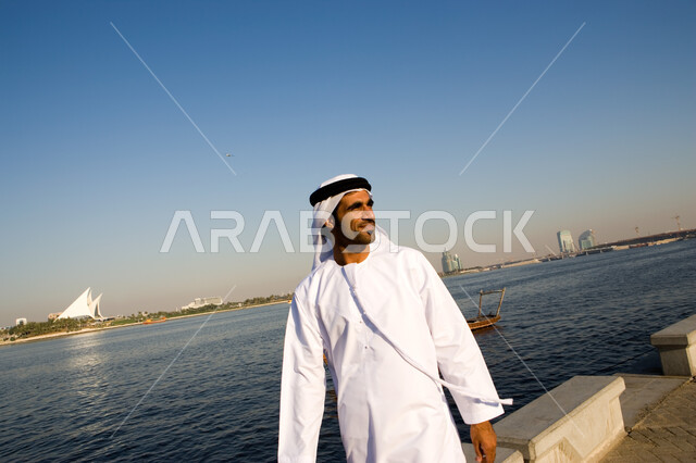 Spending vacation time enjoying the outdoors, tourism in the United Arab Emirates, gestures indicating enjoying the summer vacation, an Arab Emirati man wearing a gh