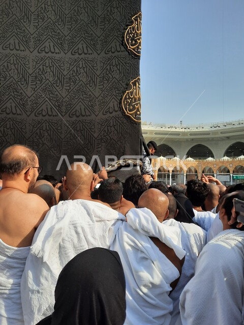 Performing the rituals of Hajj and Umrah, worshiping and drawing closer to God, a close-up of pilgrims to the Sacred House of God next to the Holy Kaaba, circumambulating around the Kaaba in Makkah Al-Mukarramah, the courtyards of the Holy Mosque of Mecca