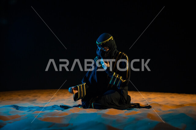 الجلوس على الرمال الذهبية الناعمة، الاعتزاز والفخر الدائم بالهوية الوطنية, مشاعر الحب والانتماء للملكة, امرأة سعودية ترتدي عباءة سوداء و تمسك تراب الوطن افتخارا بأصولها و جذورها، تأسيس الدولة السعودية الأولى 1727 م، ذكرى يوم التأسيس السعودي في 22 فبراير