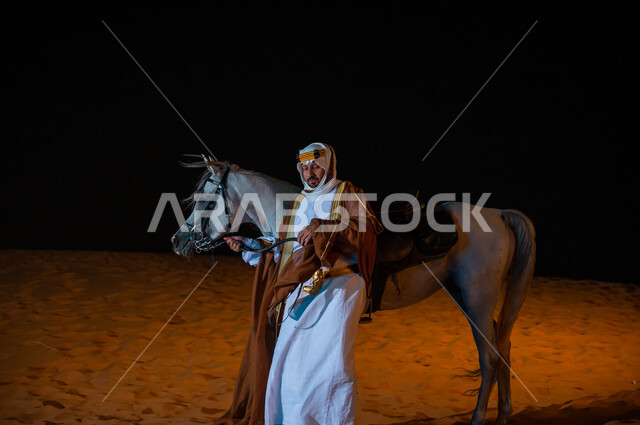 ممارسة هواية تربيه الخيول، مشاركة الجياد في المناسبات و الأعياد الوطنية ، ارتداء أزياء اهل المنطقه الوسطى ,ذكرى تأسيس المملكة 22 فبراير، التجول في الطبيعه الرملية الذهبية الناعمة، رجل سعودي يرتدي البشت والغترة يقف بجانب فرسه في الصحراء