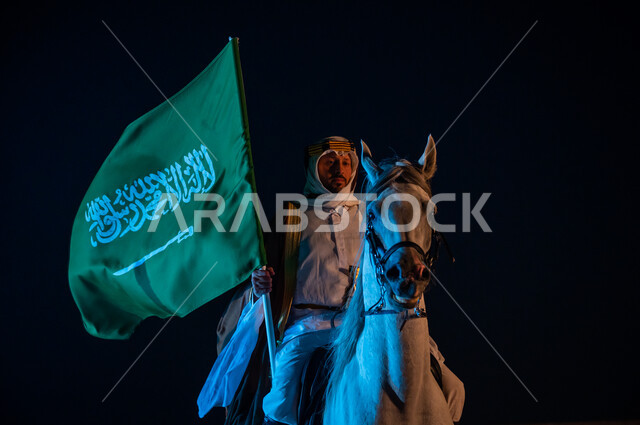 الشغف بتربية الجياد الأصيلة, ذكرى تأسيس المملكة 22 فبراير، يوم العلم 11 مارس , ممارسة هواية تربيه الخيول، الاحتفال باليوم الوطني السعودي 23 سبتمبر، رجل عربي خليجي سعودي يرتدي زي يوم التأسيس 1727 م يمتطي الخيل العربي ويحمل بيده علم المملكة السعودية