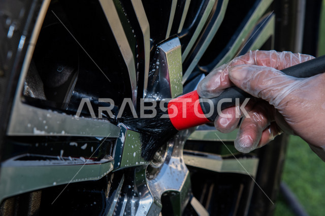 احدى الأشخاص العالمين يعمل لدى شركة متنقلة لغسيل السيارات وتلميعها في السعودية ، استخدام تقنيات لتنظيف و صيانه و تلميع السيارات ، استخدام مستحضرات ذات فعالية عالية ،التلميع الخارجي للسيارات