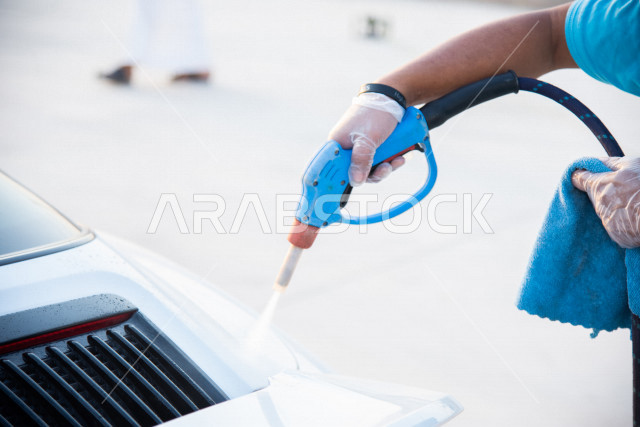 احدى الأشخاص العالمين يعمل لدى شركة متنقلة لغسيل السيارات وتلميعها في السعودية ، استخدام تقنيات لتنظيف و صيانه و تلميع السيارات ، استخدام مستحضرات ذات فعالية عالية ،التلميع الخارجي للسيارات